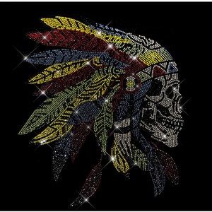 Könnte beinhalten: Ein Totenkopf aus Strass, der eine farbenfrohe Kopfbedeckung mit Federn trägt. Der Totenkopf besteht aus Strass und die Kopfbedeckung aus Strass in den Farben Rot, Gelb, Grün und Blau.