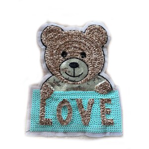May include: A brown sequined teddy bear patch holding a turquoise sign with the word "LOVE" in brown sequins. The bear has a black nose and eyes, and is set against a white background.