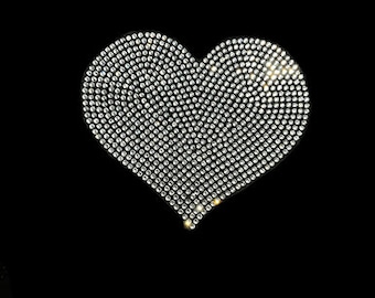 May include: A large silver heart-shaped design made of rhinestones on a black background.