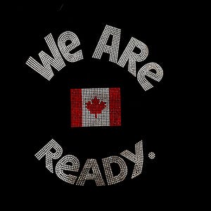Może przedstawiać: Czarna powierzchnia z tkaniny z wzorem z dżetów. Napis "We Are" jest wygięty w łuk nad kanadyjską flagą, a słowo "READY." znajduje się poniżej. Flaga i tekst składają się z małych, odblaskowych białych i czerwonych kryształków dżetów.