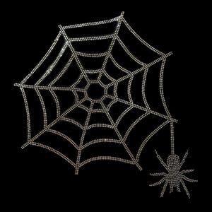 Puede incluir: Un diseño brillante de telaraña y araña, creado con numerosos pequeños adornos brillantes. La telaraña tiene una forma clásica, con la araña colgando debajo. El fondo es negro liso, resaltando los intrincados detalles del diseño.