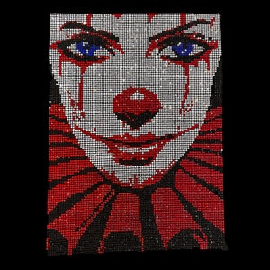 May include: A close-up of a clown face made of rhinestones. The clown has red and white makeup, a red nose, and blue eyes. The background is black.