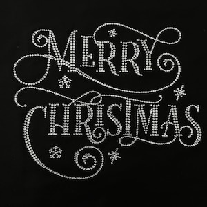 May include: A black background featuring the words "MERRY CHRISTMAS" in silver rhinestones. The text is in a decorative, cursive style with swirls and snowflake designs, perfect for festive occasions.