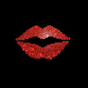 Può includere: Una forma di labbra rosse realizzata con piccoli strass rossi scintillanti su uno sfondo nero.