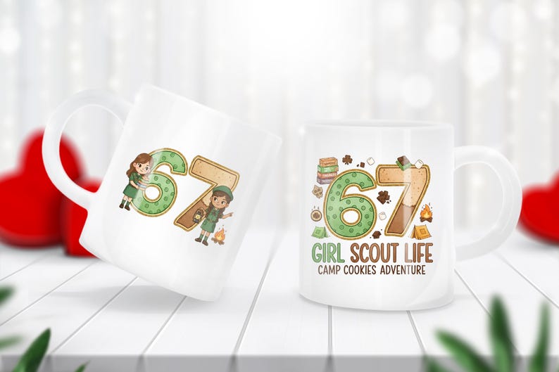 May include: Two white ceramic mugs with a design featuring the number 67 in green and brown, with illustrations of Girl Scouts. One mug has the text "GIRL SCOUT LIFE CAMP COOKIES ADVENTURE".