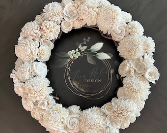 May include: A white sola wood flower wreath with a black and gold sign that says "Tiny Halos Design".