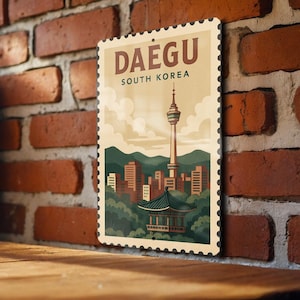 May include: A rectangular metal sign with a postage stamp design featuring the text "DAEGU SOUTH KOREA." The sign depicts a cityscape with a tall tower, buildings, and a traditional Korean building, all in a vintage style.