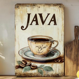 May include: A vintage-style sign with the word "JAVA" in brown lettering on a cream background. A cup of coffee with a brown saucer is in the center of the sign. The sign is surrounded by a brown wooden frame.