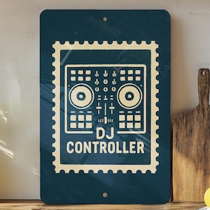 May include: A rectangular, navy blue metal sign featuring a cream-colored illustration of a DJ controller within a postage stamp border. The words "DJ CONTROLLER" are printed below the controller. The sign is mounted on a wall.