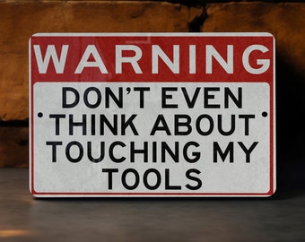 May include: A red and white warning sign with the text "WARNING DON'T EVEN THINK ABOUT TOUCHING MY TOOLS".