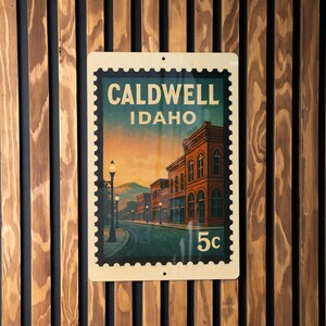 A vintage-style postage stamp from Idaho featuring a street scene with buildings and a lamppost.
