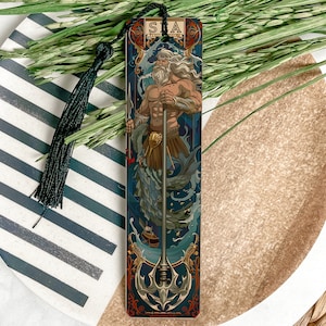 May include: A bookmark featuring a detailed illustration of a bearded man holding a trident, surrounded by water and sea creatures. The bookmark has a blue, green, and gold color scheme and the text "SEA" at the top.