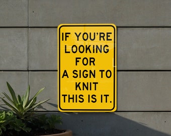 May include: A yellow sign with black text that reads "If you're looking for a sign to knit this is it."