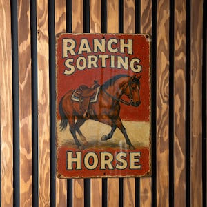 May include: A rectangular metal sign with the words "RANCH SORTING HORSE" in white lettering on a red background. The sign features a brown horse with a saddle. The sign is mounted on a wooden slatted wall.