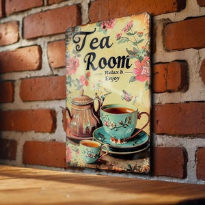 May include: Vintage-style metal sign with a teacup and teapot illustration. The sign reads "Tea Room - Relax & Enjoy".