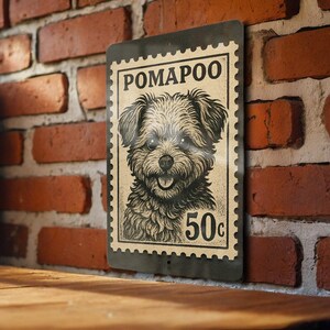 May include: A vintage-style metal sign featuring a Pomapoo dog illustration. The sign has a postage stamp design with the word "POMAPOO" at the top and "50c" at the bottom. The sign is mounted on a brick wall.