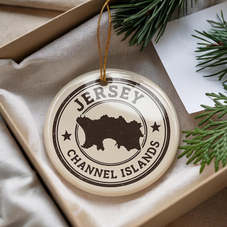 A Jersey Channel Islands ornament is displayed in a box, surrounded by pine branches.