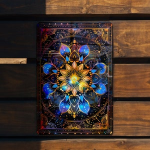 May include: A colorful mandala design with blue, gold, and pink accents on a black background. The mandala is surrounded by a gold frame with a black background.
