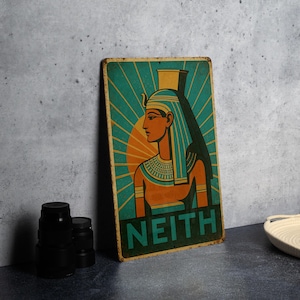 May include: Vintage metal sign featuring an illustration of the Egyptian goddess Neith. The artwork showcases Neith in profile, with a teal and orange color scheme. The word "NEITH" is displayed in bold, white letters at the bottom of the sign.