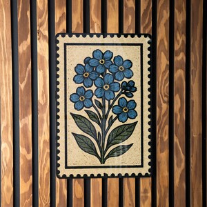 a decorative tile with a floral design, mounted on a wooden wall.