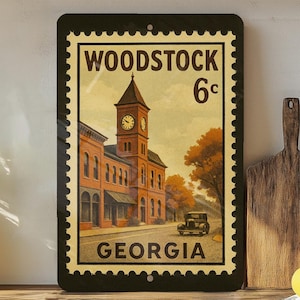 A framed vintage stamp depicting a building with a clock tower, placed on a shelf next to a wooden cutting board and some lemons.