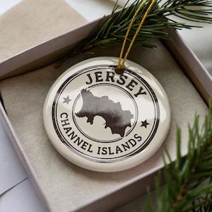 A Jersey Channel Islands ornament is displayed in a box, surrounded by pine branches.