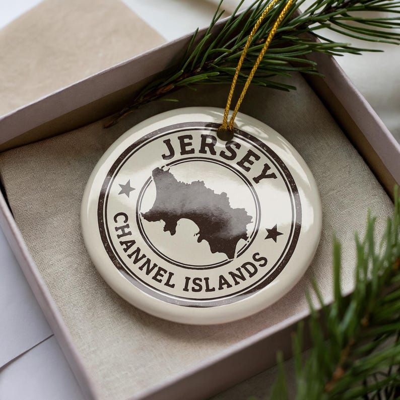 A Jersey Channel Islands ornament is displayed in a box, surrounded by pine branches.