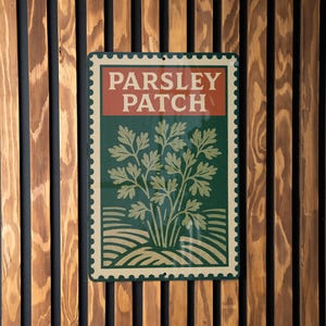 May include: Rectangular sign with the text "PARSLEY PATCH" in white letters on a red background. Below, a green field features a parsley illustration. The sign has a decorative border and is mounted on a wooden slatted wall.