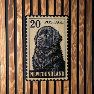 May include: A rectangular sign with a vintage postage stamp design featuring a black Newfoundland dog. The stamp reads "20 POSTAGE" at the top and "NEWFOUNDLAND" at the bottom. The sign is mounted on a wooden slatted wall.