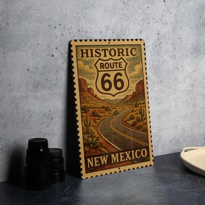 A metal sign with the text "HISTORIC ROUTE 66 NEW MEXICO" and an illustration of a desert road, likely representing the historic Route 66 in New Mexico.