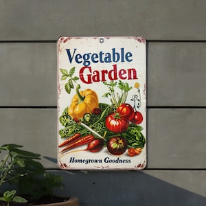 May include: A vintage-style metal sign with a red, white, and blue border. The sign features a colorful illustration of vegetables, including tomatoes, peppers, and carrots. The text on the sign reads "Vegetable Garden" and "Homegrown Goodness".