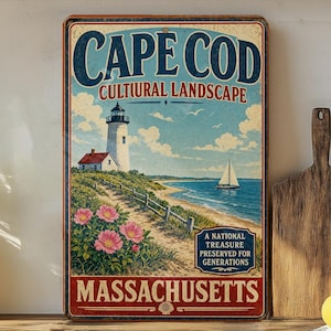 May include: Vintage metal sign featuring a Cape Cod coastal scene with a lighthouse, sailboat, and pink flowers. The sign reads "Cape Cod Cultural Landscape Massachusetts" in a distressed style, evoking a sense of nostalgia.