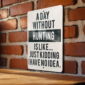 May include: A white metal sign with black text that reads "A day without hunting is like... Just kidding I have no idea."