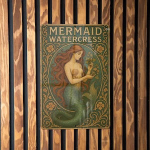 May include: A vintage-style metal sign featuring a mermaid illustration. The sign reads "MERMAID WATERCRESS" in an ornate font. The mermaid has long red hair and a green tail, holding watercress. The sign is framed with floral designs.