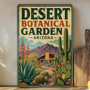 May include: A vintage-style metal sign for the Desert Botanical Garden in Arizona. The sign features a colorful illustration of desert flora, including cacti and flowering plants, with a mountain backdrop and the text "Desert Botanical Garden Arizona".