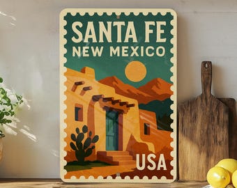 May include: A vintage-style metal sign featuring a Southwestern landscape with the text "SANTA FE NEW MEXICO USA." The sign depicts a building, mountains, and a sun in shades of orange, teal, and beige.