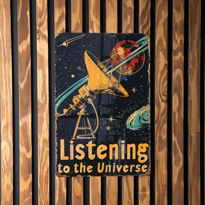 May include: A vintage-style metal sign with a black background and a yellow satellite dish. The sign reads "Listening to the Universe" in yellow letters.