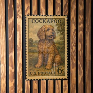 May include: A vintage-style metal sign featuring a Cockapoo dog, resembling a postage stamp. The sign includes the text "COCKAPOO" at the top and "U.S. POSTAGE 6¢" at the bottom. The dog is depicted in a field.