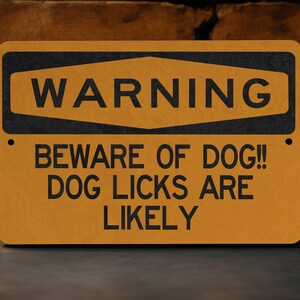 May include: A yellow warning sign with black text that reads "WARNING BEWARE OF DOG!! DOG LICKS ARE LIKELY".