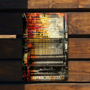 May include: A vintage-style metal sign with a colorful abstract design featuring a machine with gears and cogs. The background is a mix of red, orange, yellow, and black.