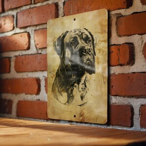 a picture of a dog hanging on a brick wall