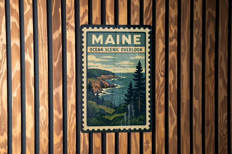 A framed poster of Maine's Ocean Scenic overlook is displayed on a wooden wall.