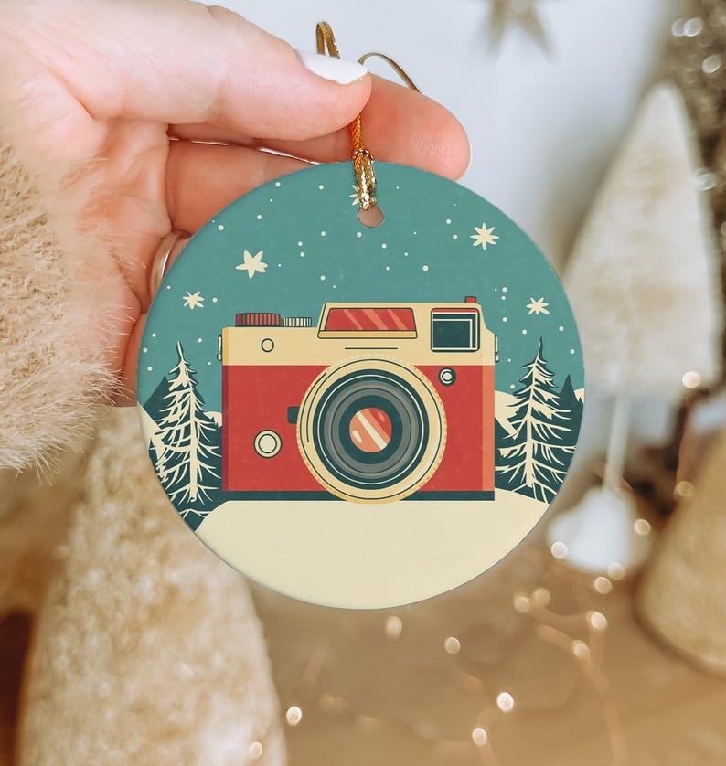 a person holding a christmas ornament with a camera on it