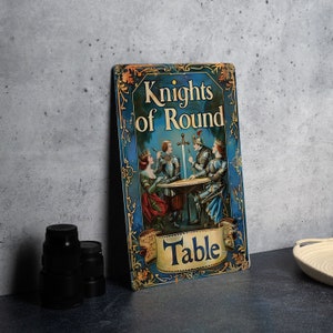 May include: A blue and gold metal sign with an illustration of four knights sitting around a round table. The sign reads "Knights of Round Table".