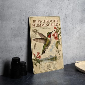 May include: A vintage-style metal sign featuring a Ruby-Throated Hummingbird illustration. The sign includes detailed drawings of the bird, flowers, and a landscape, with text describing the hummingbird's characteristics and habitat. The sign is in a distressed, aged style.
