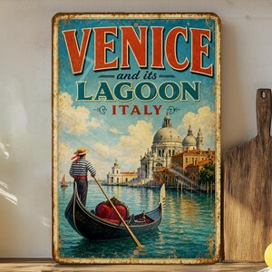 May include: Vintage metal sign with the words "VENICE and its LAGOON ITALY" in red and teal. The sign depicts a gondola on the water with a person in a striped shirt, and a church in the background. The sign has a distressed, aged look.
