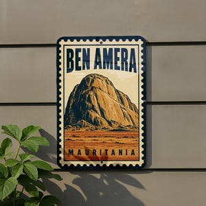 May include: A rectangular metal sign designed like a postage stamp featuring a large rock formation. The text reads BEN AMERA at the top and MAURITANIA at the bottom. The illustration shows a tan and brown landscape with a prominent monolith.