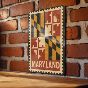 May include: A rectangular metal sign featuring the Maryland state flag design. The sign has a vintage, distressed look with a cream-colored background and the word "MARYLAND" in white. The flag design includes a black and gold checkered pattern and red crosses.