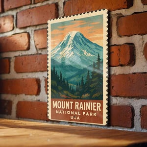 May include: A vintage-style Mount Rainier National Park USA poster. The poster features a snow-capped mountain, evergreen trees, and the text "Mount Rainier National Park USA" in a classic font. The poster has a postage stamp design.