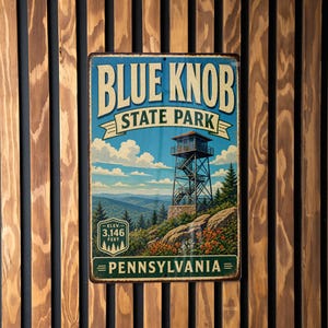 May include: A vintage-style metal sign for Blue Knob State Park in Pennsylvania. The sign features a scenic illustration of a lookout tower, mountains, and trees, with the elevation listed as 3,146 feet. The sign is mounted on a wooden slat wall.
